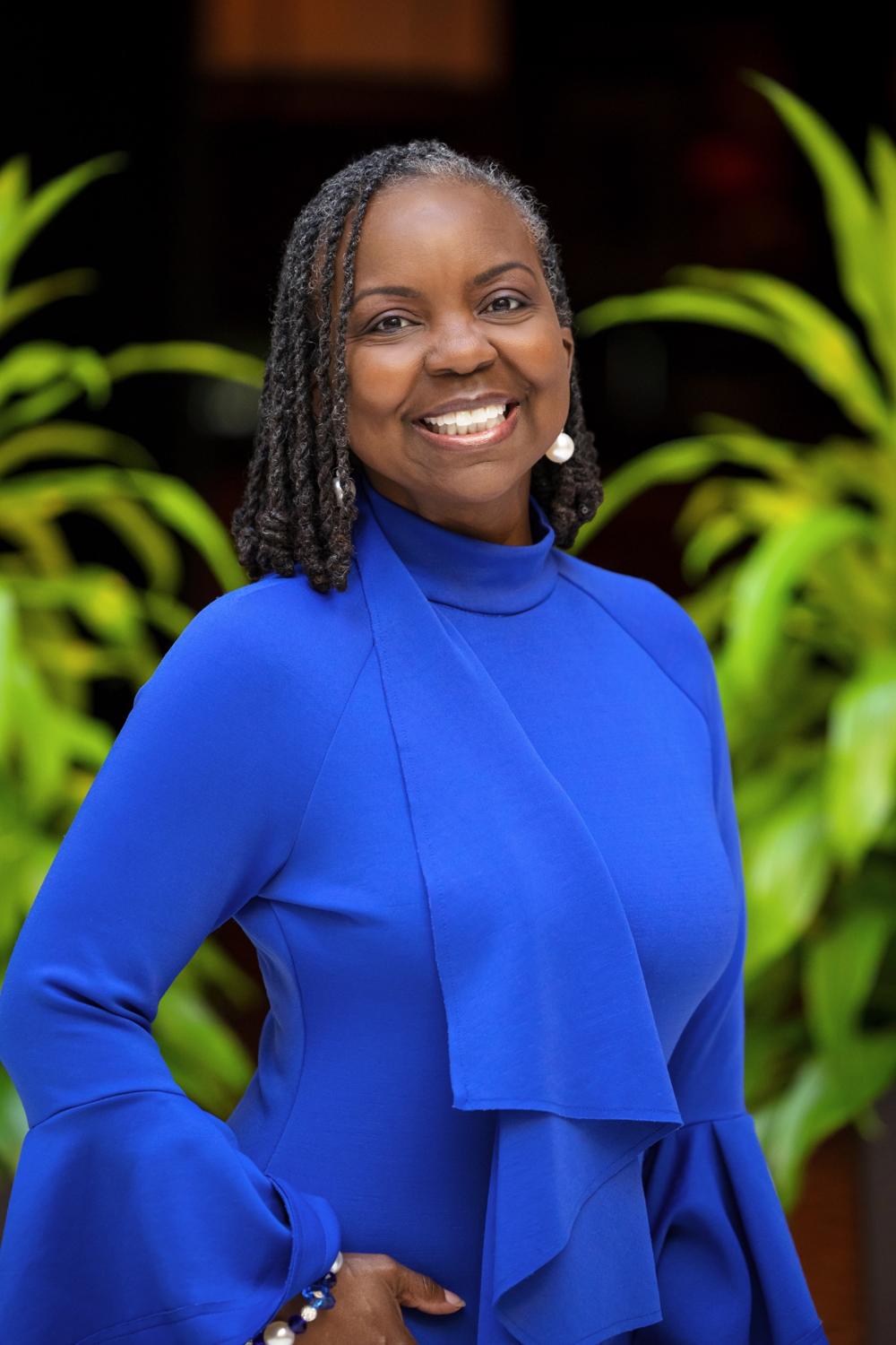 Tamara D. Harris smiling in a royal blue outfit